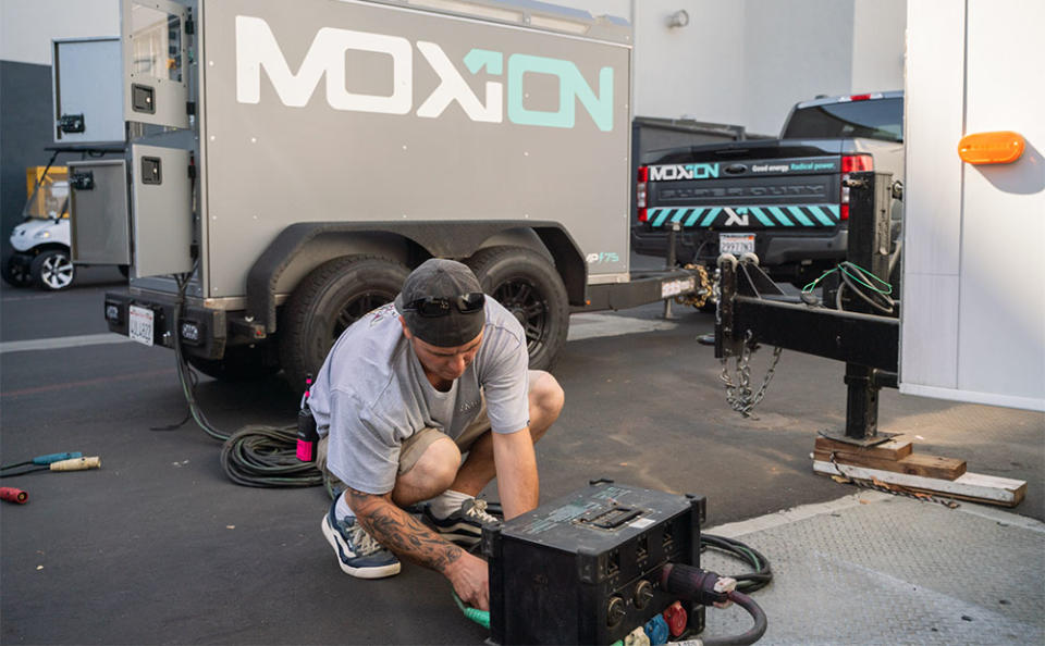 An Amazon Studios crew member plugs in a Moxion Power battery on the set.