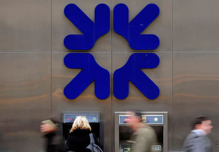 A woman uses an ATM at a Royal Bank of Scotland (RBS) branch in London, Britain, February 25, 2010. REUTERS/Toby Melville/File Photo