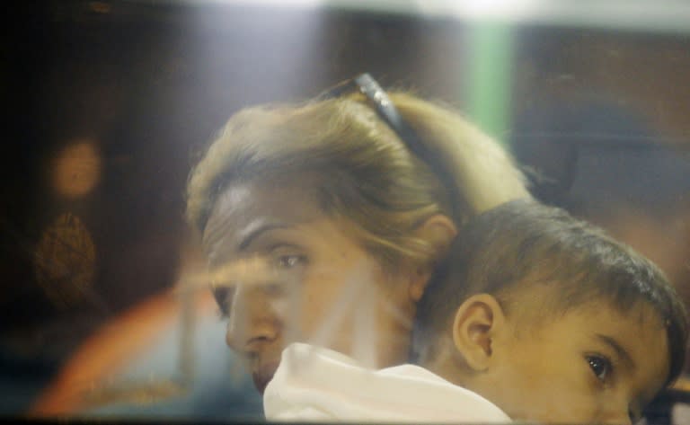 A migrant family rests on a bus as they are transported from Budapest to the Hungarian border village of Hegyeshalom, early on September 5, 2015