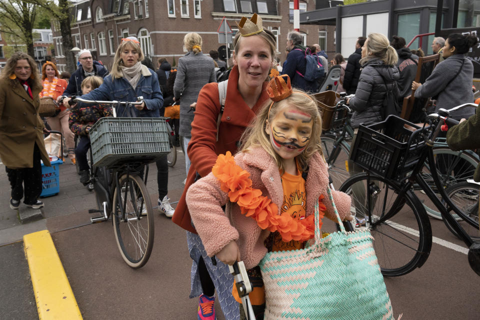 Orange-clad people head to Vondelpark after queueing at a draw-bridge to let ships pass during King's Day celebrations in Amsterdam, Netherlands, Wednesday, April 27, 2022. After two years of celebrations muted by coronavirus lockdowns, the Netherlands marked the 55th anniversary of King Willem-Alexander of the House of Orange with street parties, music festivals and a national poll showing trust in the monarch ebbing away. (AP Photo/Peter Dejong)