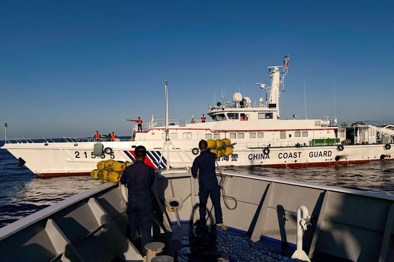 FILE PHOTO: Philippine Coast Guard personnel prepare rubber fenders after Chinese Coast Guard vessels blocked their way to a resupply mission at the Second Thomas Shoal in the South China