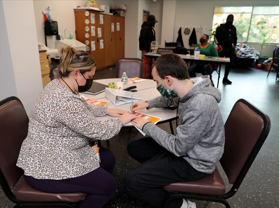 Julianne Rose, the team leader for day services at Jawonio helps Brian Dolan fill out some paperwork in a classroom at their headquarters in New City, Nov. 2, 2021.