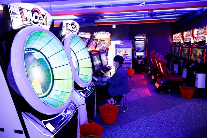 A man wearing a mask enjoys a game at a video arcade amid the coronavirus disease (COVID-19) pandemic in Seoul