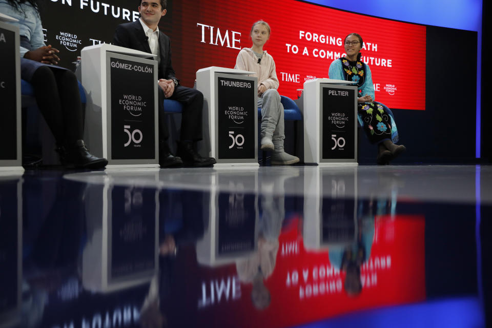 Swedish environmental activist Greta Thunberg, center, takes her seat prior to the opening session of the World Economic Forum in Davos, Switzerland, Tuesday, Jan. 21, 2020. The 50th annual meeting of the forum will take place in Davos from Jan. 20 until Jan. 24, 2020. (AP Photo/Markus Schreiber)