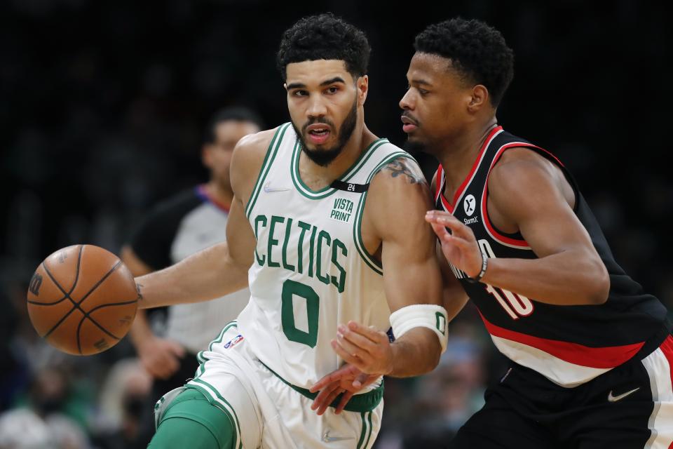 Boston Celtics' Jayson Tatum (0) drives past Portland Trail Blazers' Dennis Smith Jr. (10) during the first half of an NBA basketball game Friday, Jan. 21, 2022, in Boston. (AP Photo/Michael Dwyer)