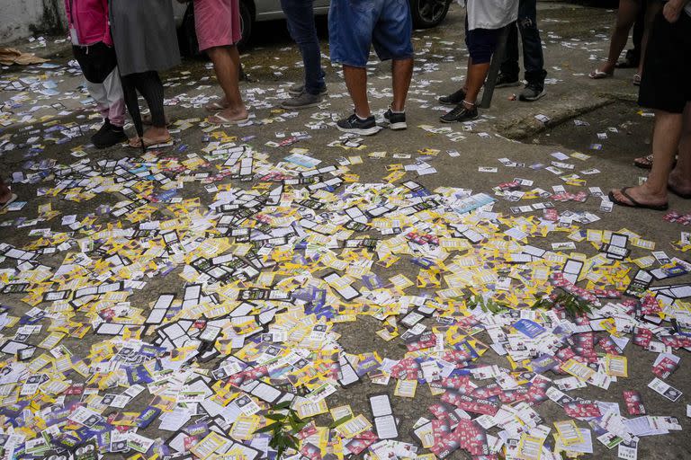 Volantes electorales yacen en la acera frente a un colegio electoral en Río de Janeiro, Brasil, el domingo 2 de octubre de 2022