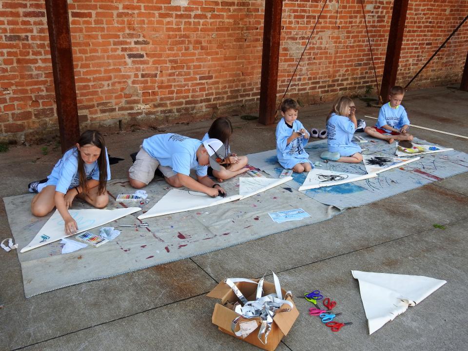 Children from The Waddling Pond Daycare in West Lafayette design large fish puppets as part of youth summer programming at the artPARK by the Pomerene Center for the Arts.