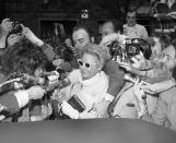 <p>Martha Mitchell carries a worn Bible as she makes her way through a throng of newsmen to give a deposition about the Watergate case to a lawyer in New York City on May 3, 1973. “I wouldn’t want to have to swear on a dictionary,” quipped the wife of former Attorney General John Mitchell. (Photo: AP) </p>