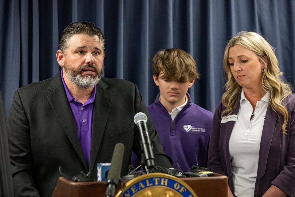Matthew Mangine, left, spoke about the need for AEDs on the sidelines while standing with his son, Joseph, and wife, Kim, during a press conference in Frankfort, Kentucky, on Feb. 21, 2023. The Mangines' son, Matthew Mangine Jr., lost his life after collapsing June 16, 2020, during soccer conditioning at St. Henry District High in Erlanger.