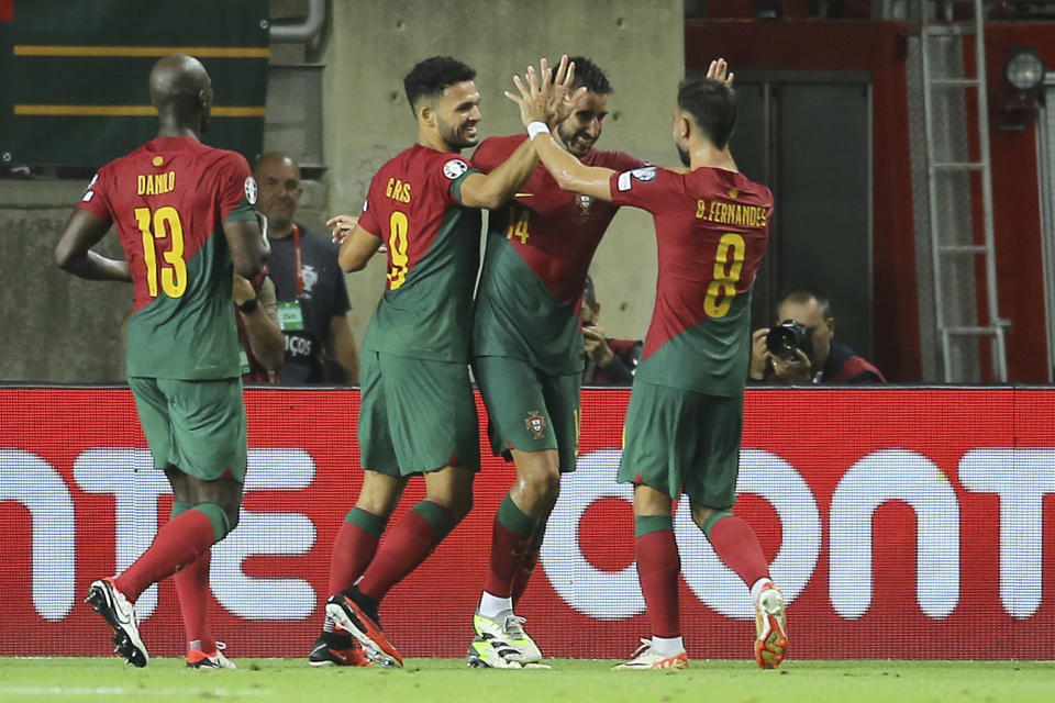 Portugal's Goncalo Inacio, 2nd right, celebrates with Bruno Fernandes, right, and Goncalo Ramos after scoring his side's fourth goal during the Euro 2024 group J qualifying soccer match between Portugal and Luxembourg at the Algarve stadium outside Faro, Portugal, Monday, Sept. 11, 2023. (AP Photo/Joao Matos)