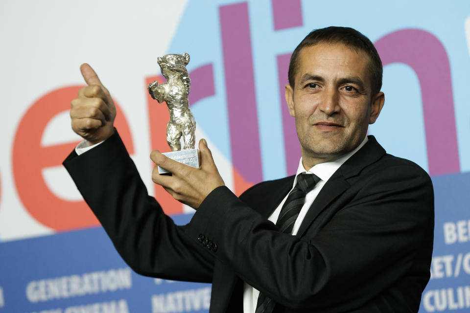 FILE - In this Feb. 16, 2013 file photo actor Nazif Mujic holds up his Silver Bear Best Actor award for his role in 'An Episode In the Life of an Iron Picker' at the 63rd edition of the Berlinale, International Film Festival in Berlin, Germany. Mujic, a Roma from a tiny village in Bosnia, won the Silver Bear award in 2013. Now, almost a year later, the movie star has turned into an asylum seeker. Mujic is back in Berlin, but this time he came with his family to apply for asylum, was rejected by the German authorities and is desperately fighting his deportation back to Bosnia in March. (AP Photo/Markus Schreiber, File)