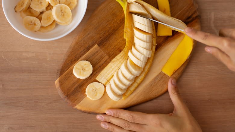 Person slicing fresh banana