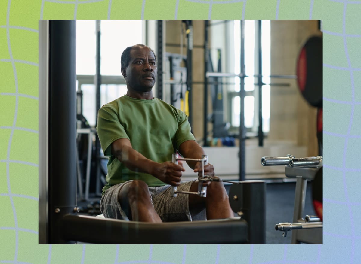 focused senior man doing cable row at the gym