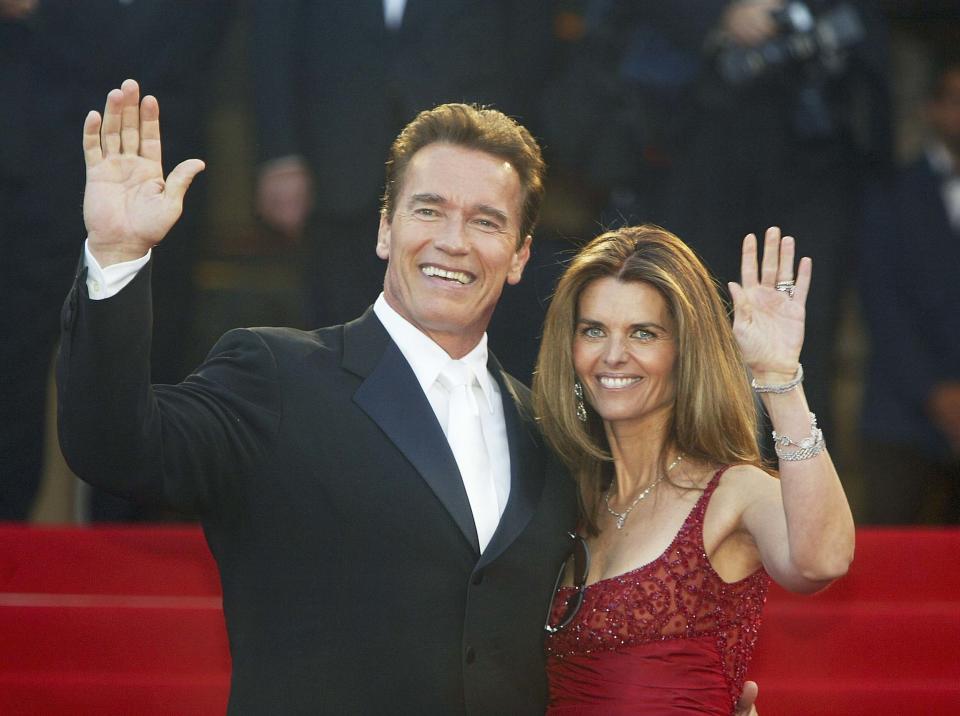 Arnold Schwarzenegger with his former wife Maria Shriver wave to fans as the couple arrives for the screening of the film 