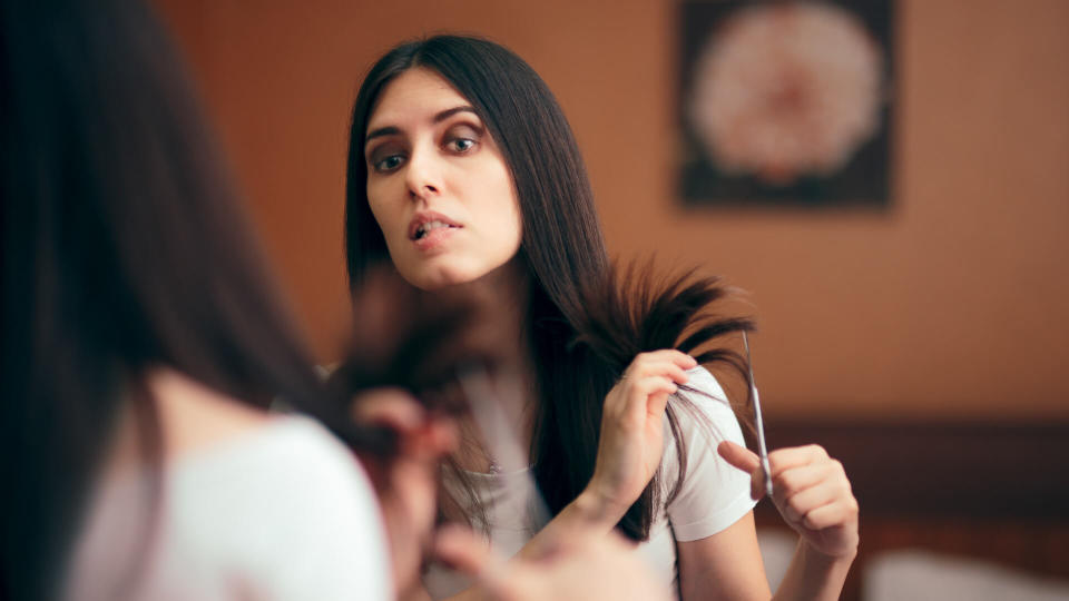 Girl changing looks giving herself a with DIY cut.