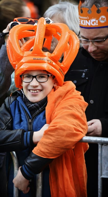 A boy wearing an orange crown waits for the arrival of the royal family members in Tilburg