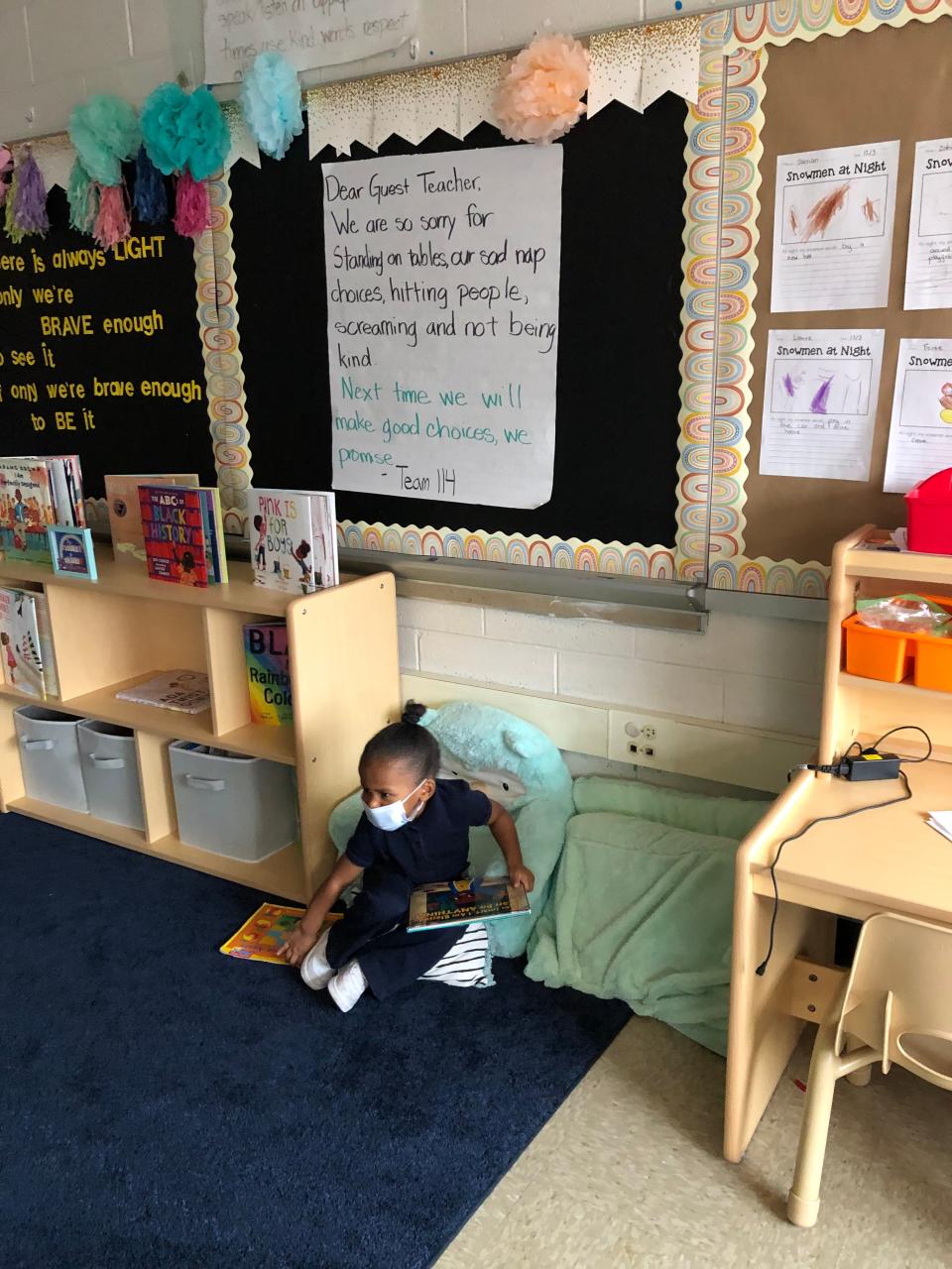 In a preschool classroom at George Washington Carver Academy in Milwaukee, a preschooler enjoys picture books in a child-sized chair. In 2020, the school bought the book “Courageous Conversations About Race” for every staff member and held virtual book discussion groups every two weeks. “It was extremely powerful. It opened up that avenue, that space to have real conversations and to hear sides from different races,” Principal Kristin Hinds said.