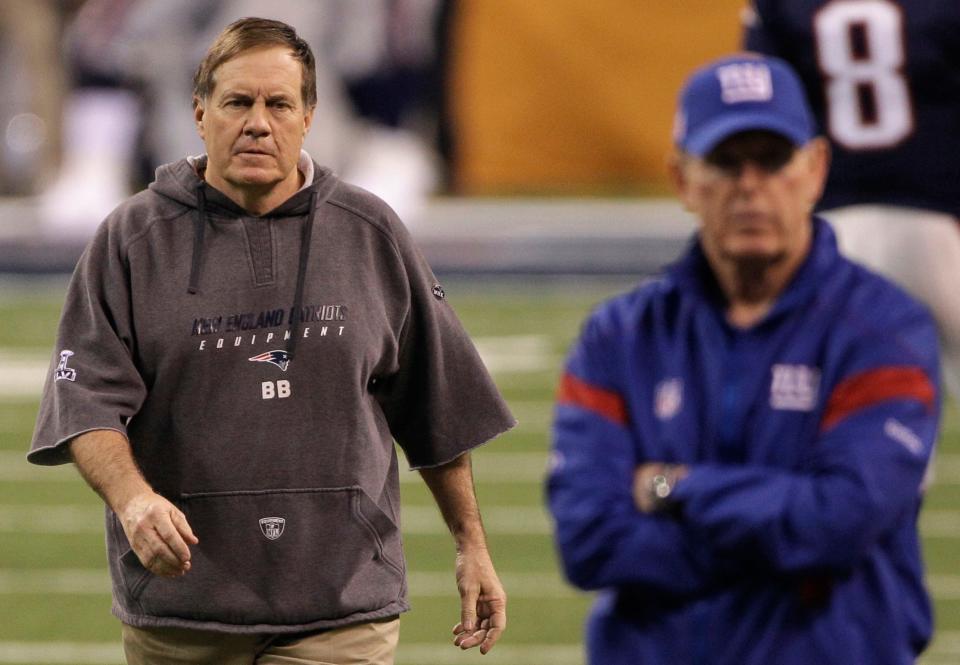 New England Patriots head coach Bill Belichick, left, approaches New York Giants head coach Tom Coughlin while players warm up before their NFL Super Bowl XLVI football game, Sunday, Feb. 5, 2012, in Indianapolis. (AP Photo/David Duprey)