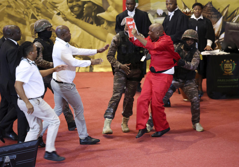 FILE - Opposition Economic Freedom Fighters party leader Julius Malema, center right, is removed by presidential task force as South African President Cyril Ramaphosa attempts to deliver his State of the Nation address to MP's in Cape Town, South Africa, on Feb. 9, 2023. The leaders of a boisterous South African opposition party have had their ban from attending a speech this week by President Cyril Ramaphosa to open the new parliamentary session upheld by a court. The leader, deputy leader and four other officials with the Economic Freedom Fighters — the third biggest party in Parliament — will not be allowed at Thursday's State of the Nation Address. (Esa Alexander/Pool Photo via AP, File)