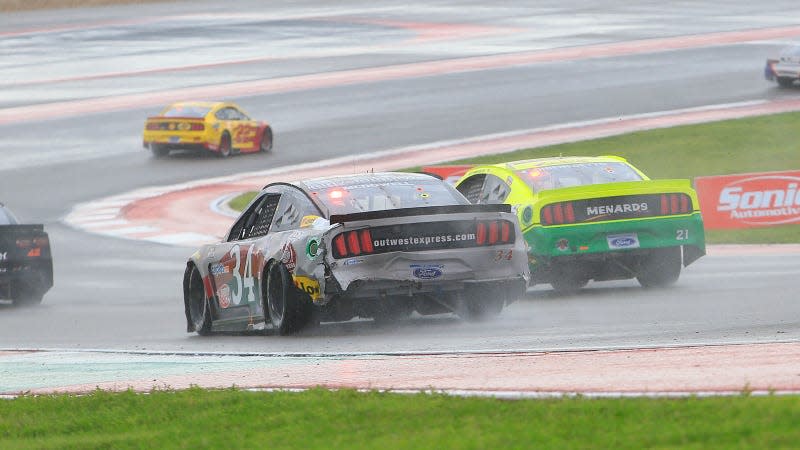 A photo of two NASCAR racers competing on a wet track. 