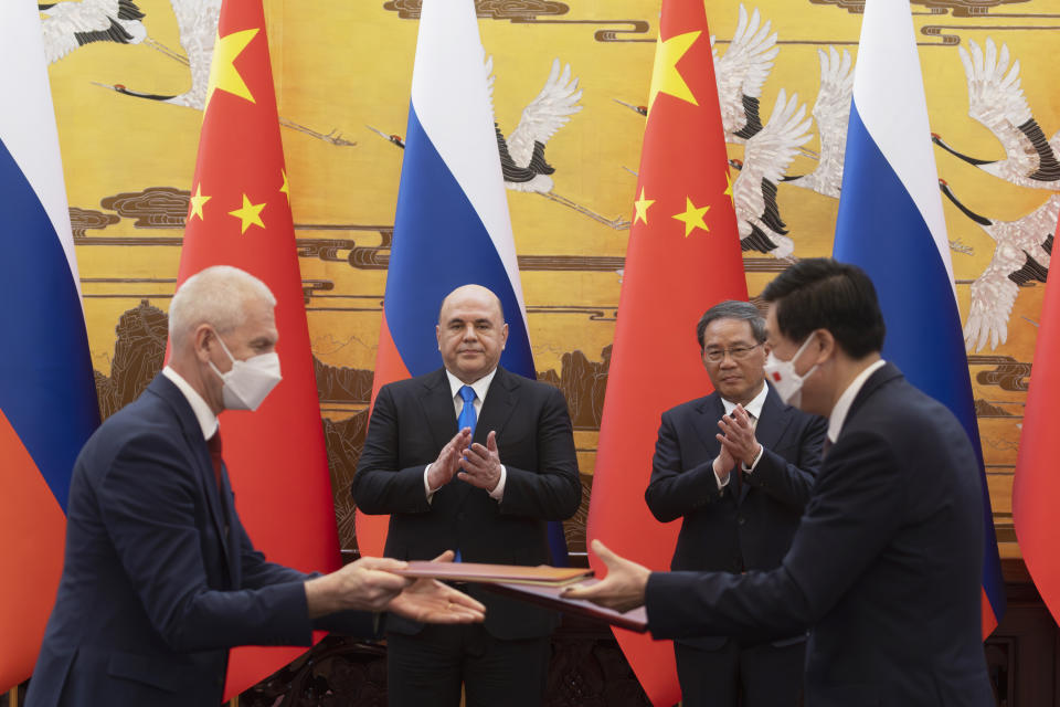 Russian Prime Minister Mikhail Mishustin, back left, and Chinese Premier Li Qiang attend a signing ceremony in Beijing, China, Wednesday, May 24, 2023. (Thomas Peter/Pool Photo via AP)