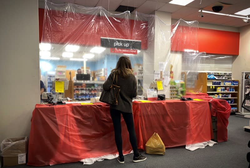 Woman waits behind a sheet of protective plastic at the pharmacist's counter at a CVS Pharmacy during the outbreak of coronavirus disease (COVID-19) in New York