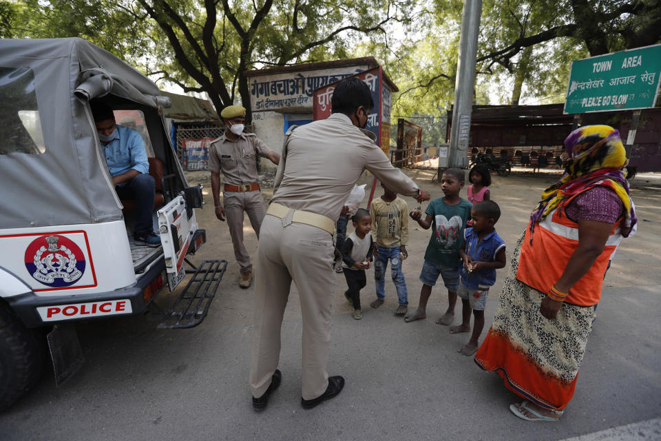A policeman distributes tea during lockdown to prevent the spread of new coronavirus in Prayagraj, India, Saturday, April 25, 2020. As governments around the world try to slow the spread of the coronavirus, India has launched one of the most draconian social experiments in history, locking down its entire population, including an estimated 176 million people who struggle to survive on $1.90 a day or less. (AP Photo/Rajesh Kumar Singh)