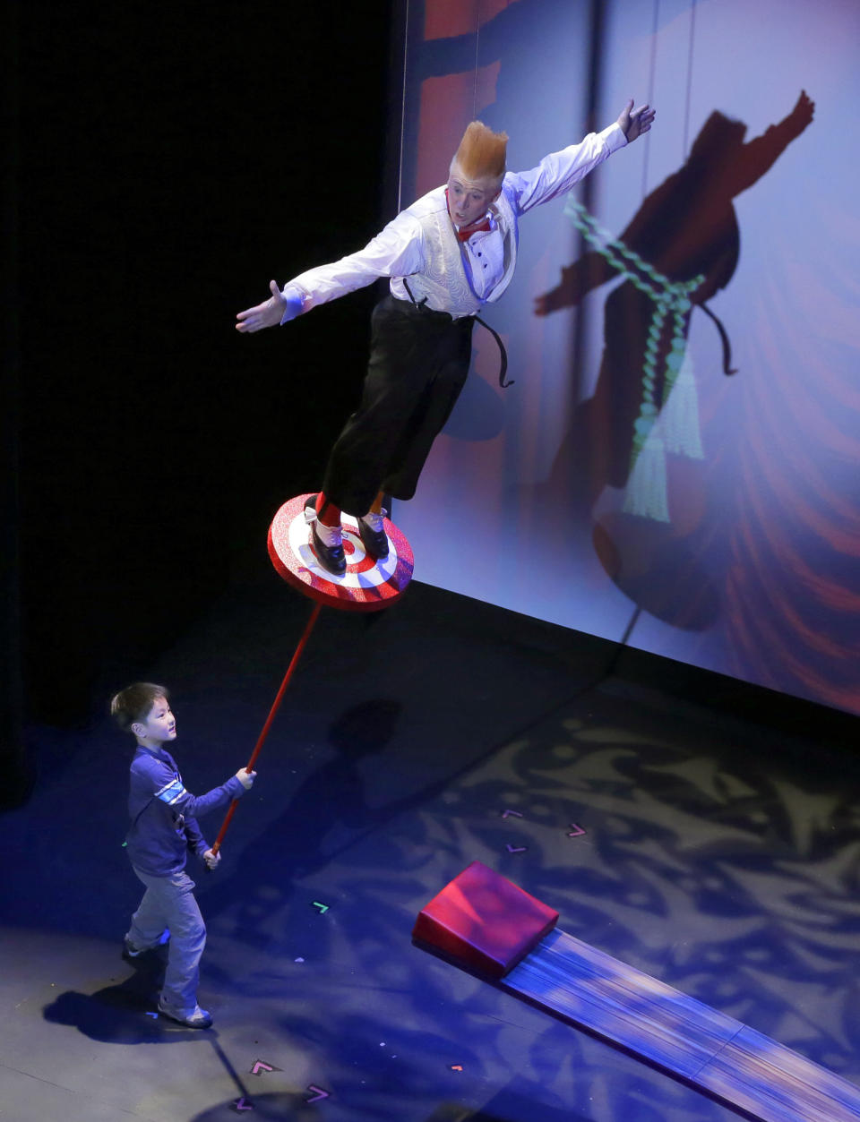 This March 23, 2013 photo shows Bello Nock, performing a stunt with the assistance of a young audience member, during his "Bello Mania" show at the New Victory Theater in New York. Nock, a seventh-generation circus performer, is never offstage during the 90-minute performance, which combines slapstick clowning with death-defying aerial stunts. He performs through March 31 at the New Victory before moving on to the Canadian side of Niagara Falls and then a 10-week stint at the Beau Rivage Casino in Biloxi, Miss. (AP Photo/Richard Drew)