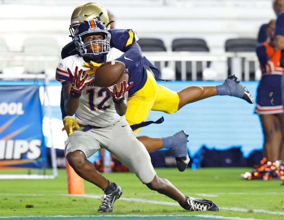 Homestead wide receiver Cortez Mills (12) attempts to catch a pass in the end zone as St. Thomas Aquinas Kimari Robinson (5) defends during the 2022 FHSAA State Championships-Class 3M at DRV PNK Stadium in Ft. Lauderdale on Thursday, December 15, 2022. Pass interference was called on Robinson in the second quarter.