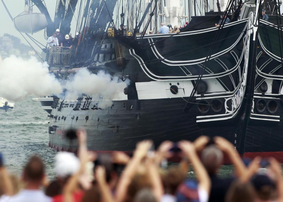 The USS Constitution fires one of her guns in Boston Harbor as a crowd looks on from the shore in Boston, Sunday, Aug. 19, 2012. The USS Constitution, the U.S. Navy's oldest commissioned war ship, sailed under her own power Sunday for the first time since 1997. The event was held to commemorate the 200th anniversary of the ship's victory over HMS Guerriere in the War of 1812. (AP Photo/Steven Senne)