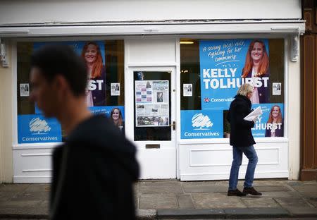 People walk past the by-election campaign office for the Conservative Party in Rochester, in southeastern England, November 11, 2014. REUTERS/Andrew Winning