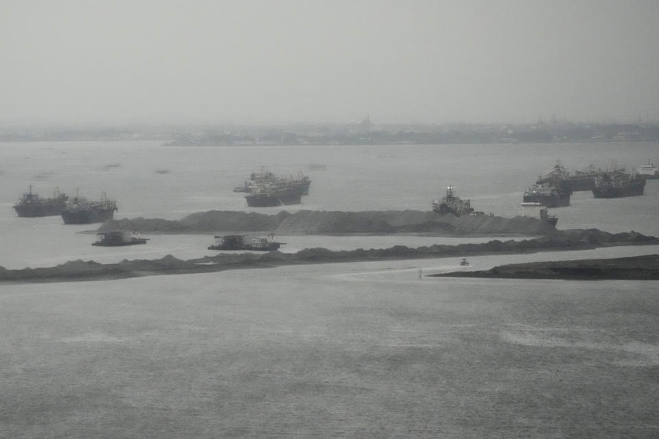 Barges are seen beside reclamation sites in the rain in Manila bay, Philippines on Wednesday, Aug. 2, 2023, The United States expressed concerns over major reclamation projects near its heavily secured embassy, which sits on one edge of Manila Bay, due to the involvement of a blacklisted Chinese company, the U.S. Embassy said Wednesday. (AP Photo/Aaron Favila)