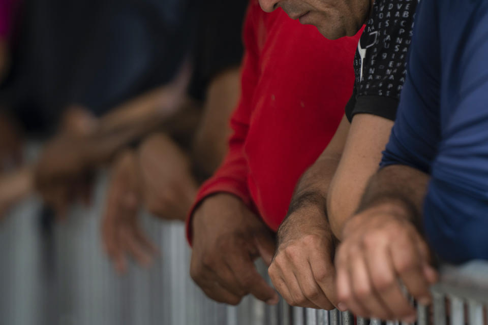 Migrants wait at the Gateway International Port of Entry under U.S. Customs and Border Protection custody in Brownsville, Texas, Friday, May 5, 2023, before being sent back to Mexico under Title 42. (AP Photo/Veronica G. Cardenas)