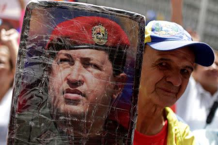 A government supporter holds up a photograph of Venezuela's late President Hugo Chavez during a rally in support of Venezuela's President Nicolas Maduro in Caracas, Venezuela May 22, 2017. REUTERS/Marco Bello