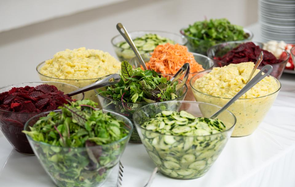 Various salads are served at a buffet during a corporate event.
