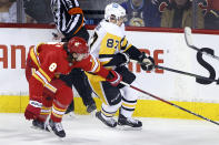 Calgary Flames' Christopher Tanev, left, reaches around Pittsburgh Penguins' Sidney Crosby during the first period of an NHL hockey game, Monday, Nov. 29, 2021 in Calgary, Alberta. (Larry MacDougal/The Canadian Press via AP)