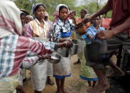 Tea garden workers collect drinking water during a break inside Aideobarie Tea Estate in Jorhat in Assam, India, April 21, 2015. REUTERS/Ahmad Masood