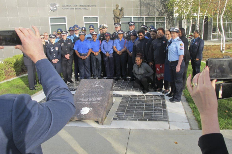 Law enforcement representatives from Australia, New Zealand and Papua New Guinea pose with their Alaska counterparts after a police remembrance ceremony Friday, Sept. 27, 2019, in Anchorage, Alaska. Participants were among delegates attending an international police convention who observed their region's fallen officers in the quickly planned ceremony with their Alaska counterparts. (AP Photo/Rachel D'Oro)