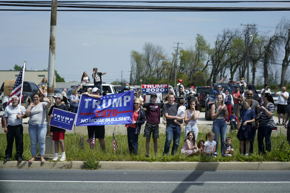 People watch as a motorcade with President Donald Trump dives past on Thursday, May 14, 2020, in Allentown, Pa. (AP Photo/Evan Vucci)