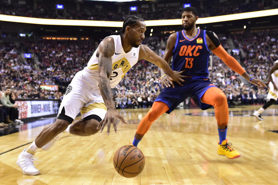 Toronto Raptors forward Kawhi Leonard (2) moves past Oklahoma City Thunder forward Paul George (13) during first-half NBA basketball game action in Toronto, Friday, March 22, 2019. (Frank Gunn/The Canadian Press via AP)