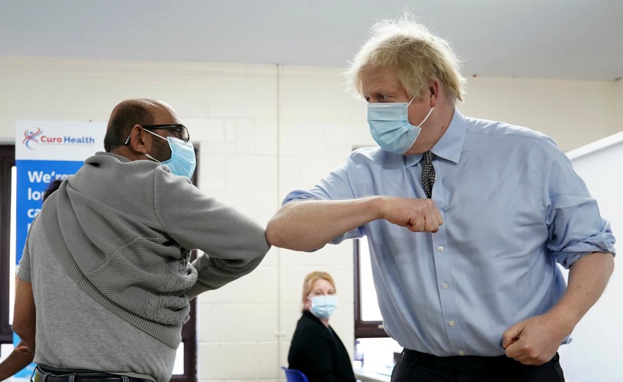 Britain's Prime Minister Boris Johnson (R) wearing a protective face covering to combat the spread of the coronavirus, elbow bumps Ismail Patel (L) after Ismail receives his jab, during a visit to a coronavirus covid-19 vaccination centre, the Al-Hikmah Vaccination Centre in Batley, northern England on February 1, 2021. - Britain has set itself an ambitious goal of vaccinating 15 million of the most vulnerable people by mid-February, and the entire adult population by the autumn. A total of 598,389 people in the UK received a first vaccine dose on Saturday, the highest daily figure since the rollout began. (Photo by Jon Super / POOL / AFP) (Photo by JON SUPER/POOL/AFP via Getty Images)