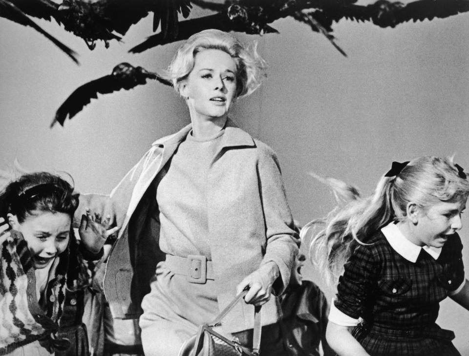 American actor Tippi Hedren and a group of children run away from the attacking crows in a still from the film 'The Birds'