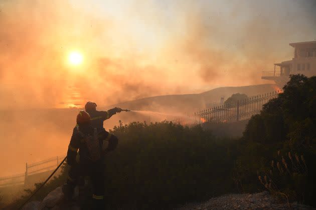 Firefighters extinguish a house burning during a wildfire in southeast Attica in Lagonisi, Greece on 17, July 2023.
