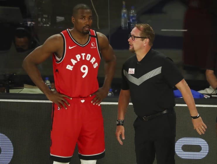 Serge Ibaka listens to Toronto coach Nick Nurse during a playoff game against Brooklyn on Aug. 23, 2020, in Orlando, Fla.