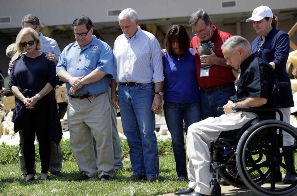 Vice President Mike Pence, center, holds the hand of