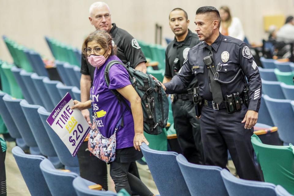 Police direct a spectator out of the Kenneth Hahn Hall of Administration after a protest