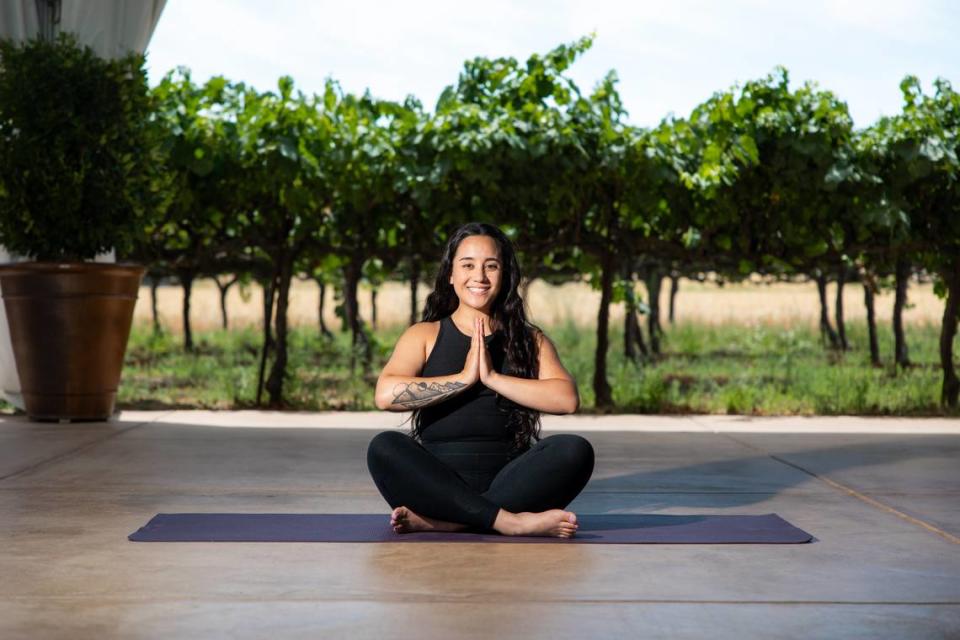 Registered yoga teacher Kathryn Luna sits cross-legged on a yoga mat at Scribner Bend Vineyards at 9051 River Road in Sacramento County. The Sacramento resident teaches outdoor yoga classes at the vineyard through Aug. 25.