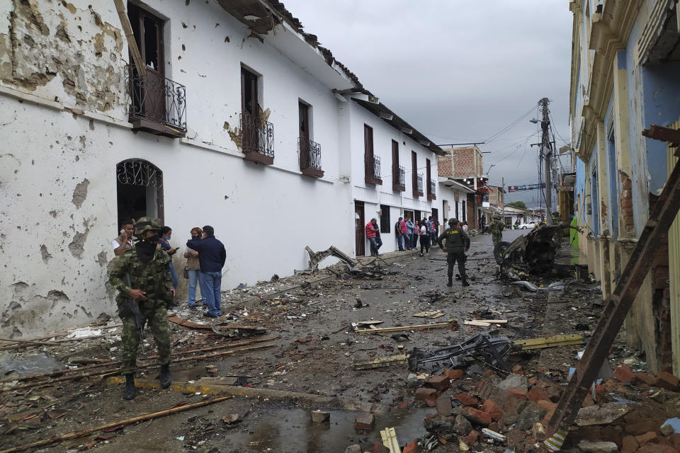 In this photo released by the press office of Corinto soldiers and civilians stand outside the City Hall of Corinto, Colombia, after the explosion of a car bomb on Friday, March 26, 2021. (Francy Otela, Corinto Press Office via AP)
