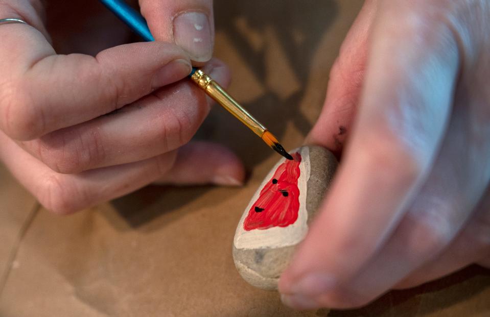 Melissa Routt decorates a rock for her Fishers Rocks! group Tuesday, May 31, 2022 at her home in Fishers. She and others paint rocks and hide them in public for people to find to brighten the day of the people who find them.