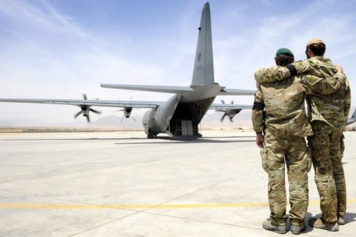 Two Australian special forces commandos embrace as a C-130 carrying the coffin of a fallen soldier departs Tarin Kot Airfieldat in Uruzgan, Afghanistan in 2011. Australia has so far lost 32 soldiers in the Afghan war